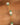 Close-up of a gold chain bracelet with pearls and green beads on a wrist.