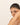 Woman touching her face wearing a delicate bracelet with a plain background