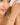 Woman wearing a gold bracelet with turquoise stones on a plain background