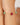 Bracelet with pink and green beads on a wrist against a neutral background