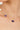 Gold necklace with purple gemstones and a pearl on a woman's neck