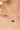 Gold necklace with purple gemstones and a pearl on a woman's neck