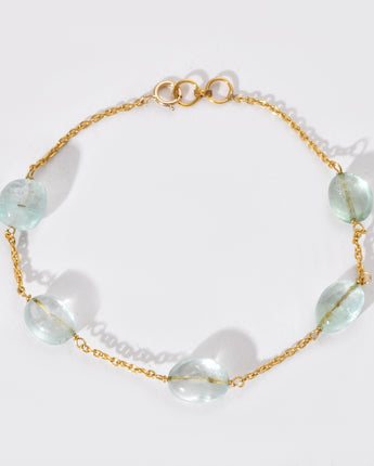 Gold bracelet with white gemstones on a white background