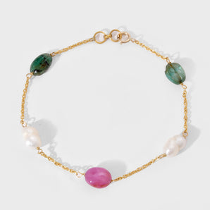 Bracelet with gold chain, green, pink, and white gemstone on a white background