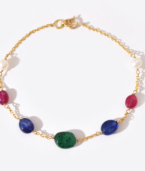 Gold bracelet with colorful gemstones on a white background