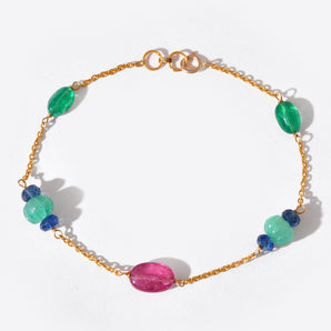 Gold bracelet with colorful beads on a white background