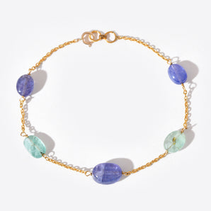 Bracelet with gold chain and multicolored beads on a white background