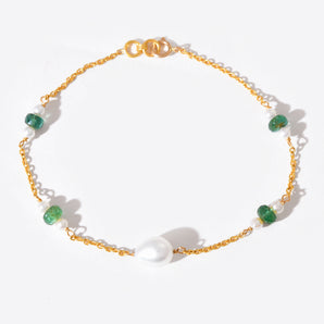 Gold bracelet with green gemstones on a white background