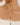 Gold chain necklace with green and pink beads on a blurred background