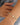 Bracelet with green beads and a pearl on a wrist against a blurred background