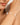 Close-up of a woman's arm wearing a gold bracelet with pearls.