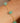 Gold bracelet with green beads on a wrist against a neutral background