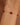 Gold bracelet with red beads on a wrist against a blurred background