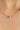 Gold chain necklace with green and pink beads on a woman's neck