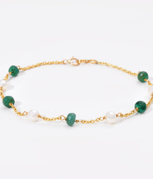 Bracelet with green gemstones and gold chain on a white background