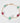 Bracelet with gold chain and green and pink beads on a white background