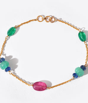 Gold bracelet with colorful beads on a white background