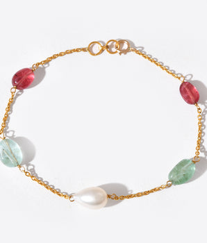 Gold bracelet with colorful beads on a white background