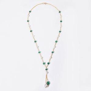 Necklace with green and white beads on a light gray background